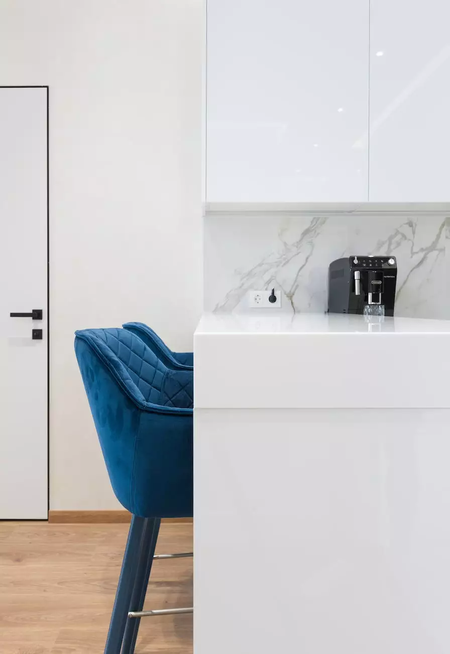 White kitchen counter and veined backsplash beside a blue chair